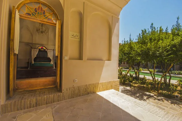 ورودی قوسی خانه عامری ها در کنار باغ