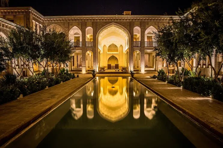 حیاط شبانه خانه عامری ها با حوض و نمای قوسی