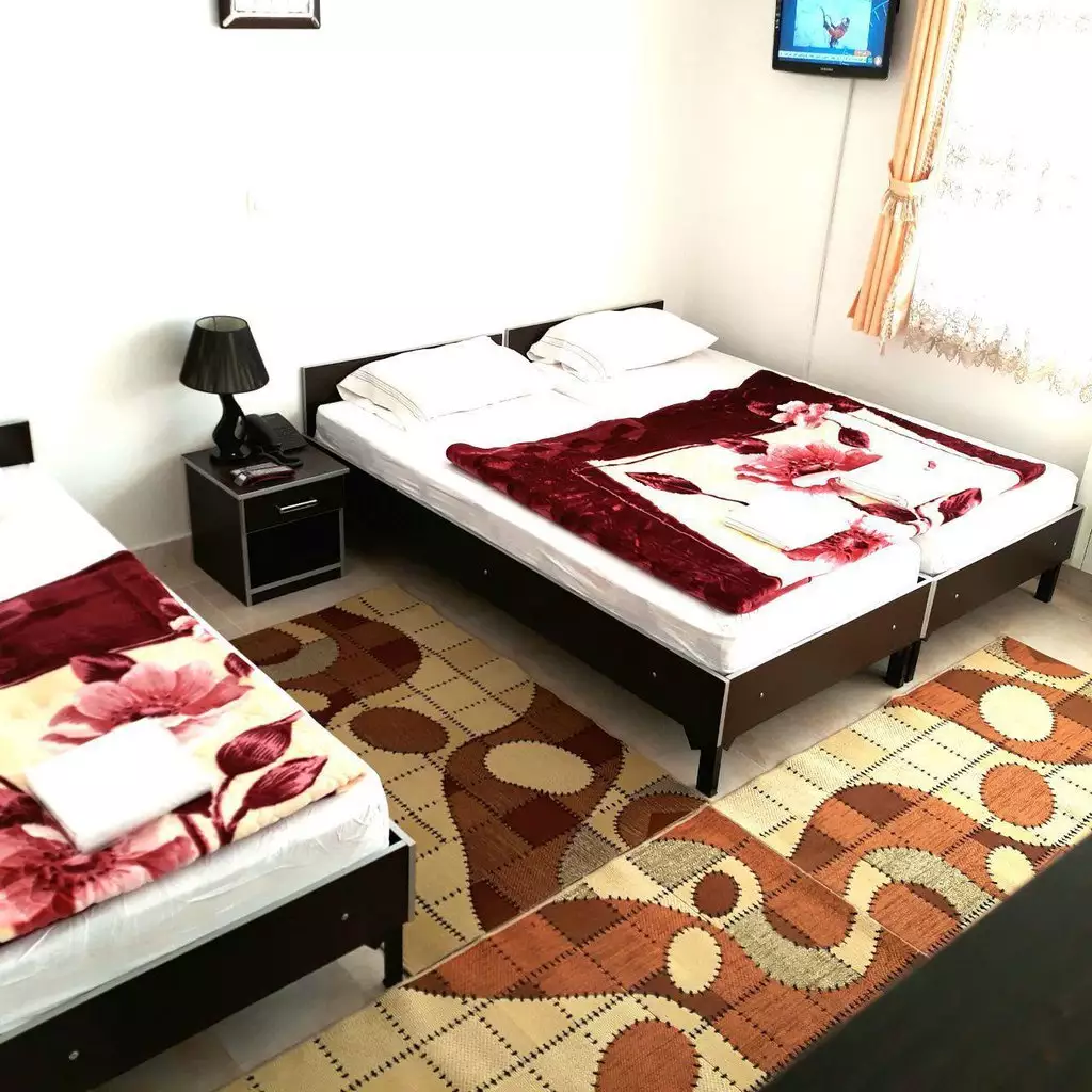 تخت‌های اتاق هتل صحت با روتختی گل‌دار