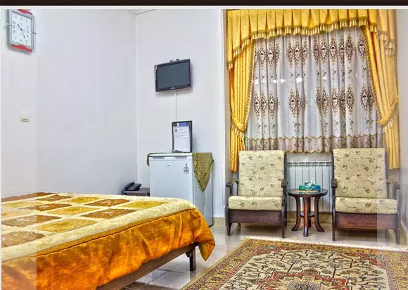 اتاق هتل صحت با تخت، مبل و پرده طلایی