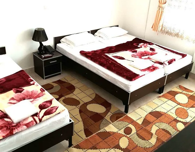 اتاق صحت با دو تخت و روتختی گل‌دار