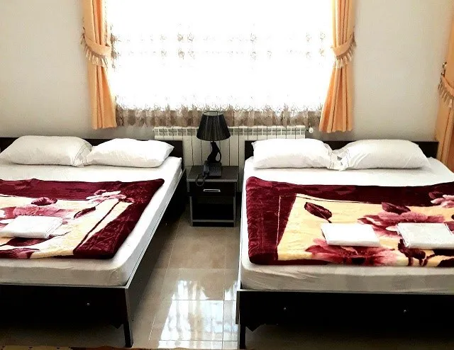 دو تخت کنار پنجره در هتل صحت
