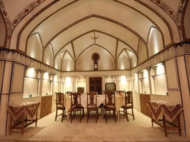 سالن غذاخوری مهینستان راهب با میز چوبی زیر طاق گنبدی