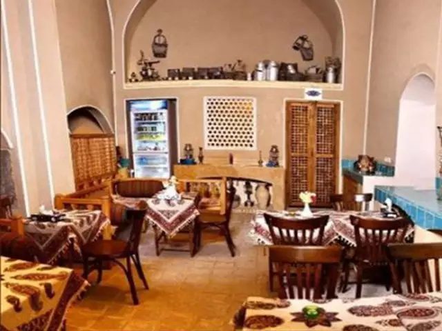 فضای غذاخوری سنتی با میزهای چوبی در مهینستان راهب