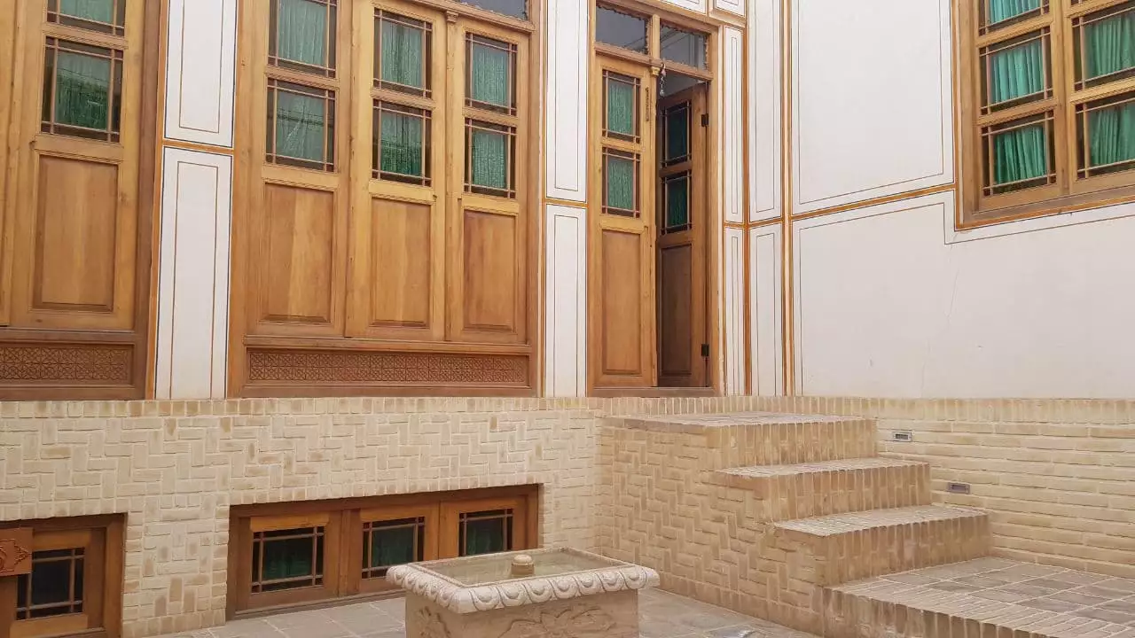 حیاط مهینستان راهب با درهای چوبی و حوض سنگی