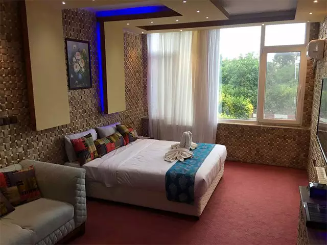 اتاق خواب با تخت دونفره و پنجره رو به فضای سبز هتل جهانگردی چلندر