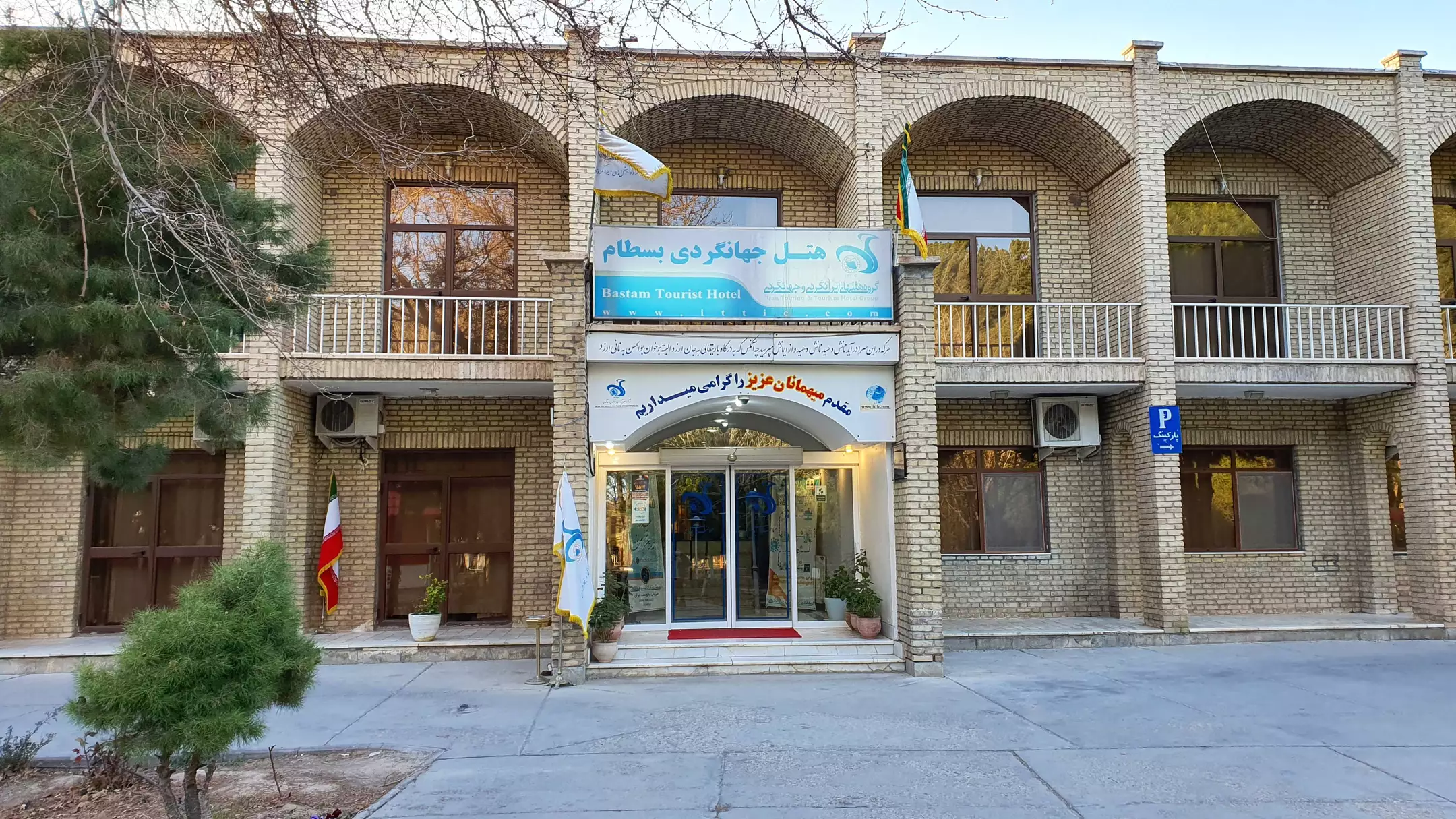 نمای ورودی هتل جهانگردی با نمای آجری و پنجره‌های قوسی