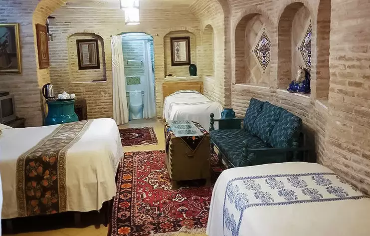 اتاق آجری هتل بخردی با سه تخت و مبل