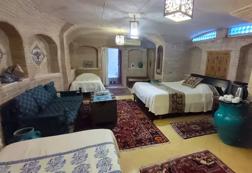 اتاق سنتی هتل بخردی با فرش و تخت‌های متعدد