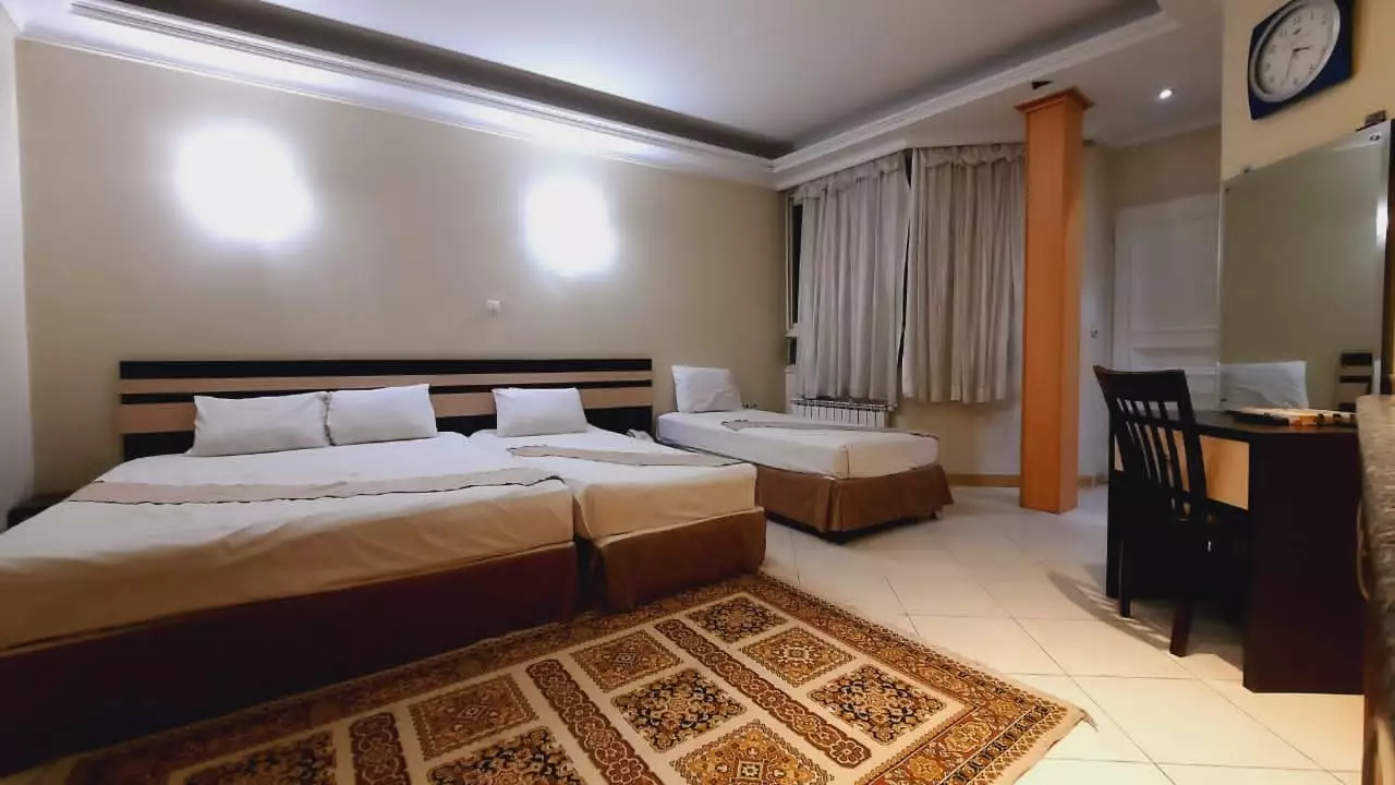 اتاق هتل هامون با سه تخت و میز کار
