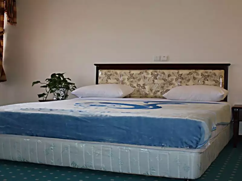 تخت دونفره با روتختی آبی در هتل جهانگردی