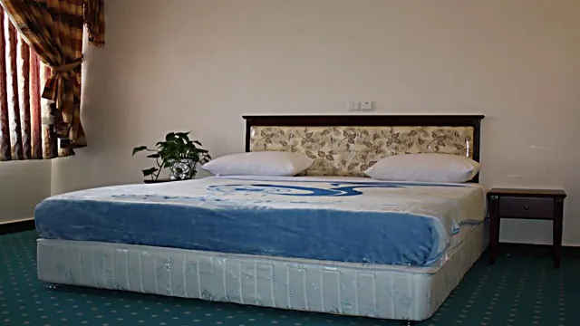 تخت دونفره با روتختی آبی در هتل جهانگردی