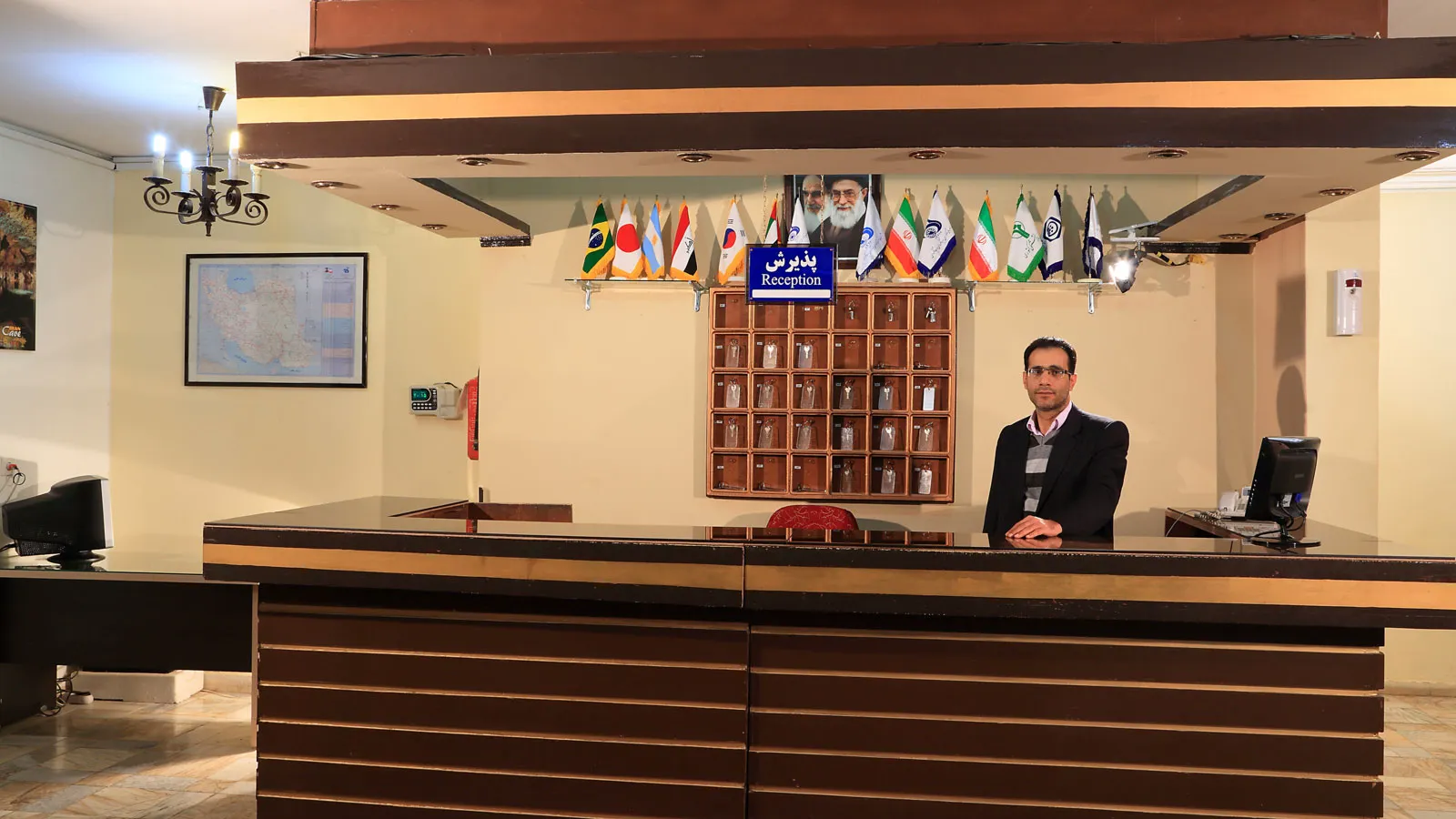 پذیرش هتل جهانگردی غار علیصدر با کارمند و پرچم‌ها