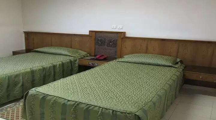 دو تخت یکنفره با روتختی سبز در جهانگردی تخت جمشید