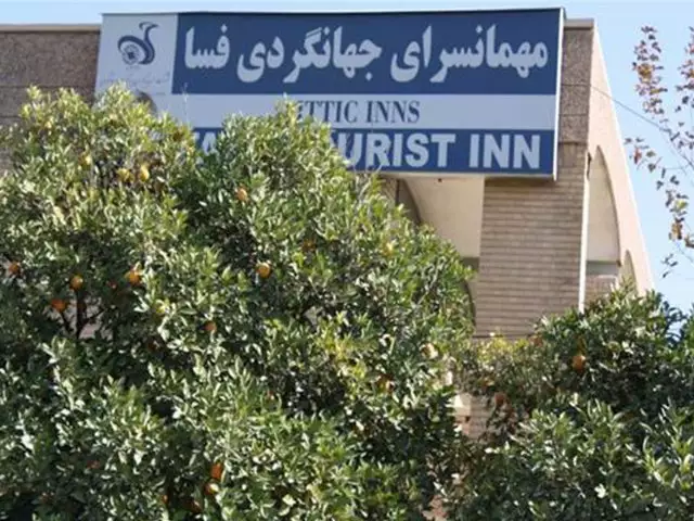 تابلوی مهمانسرای جهانگردی میان درختان پرتقال