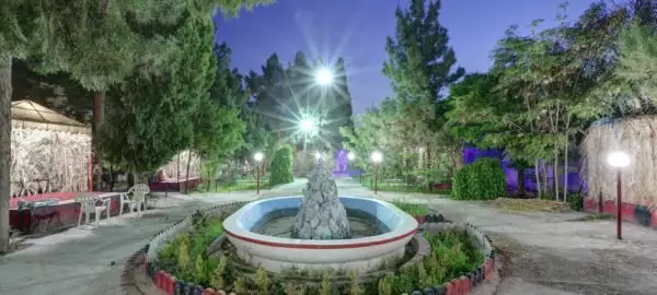 باغ هتل جهانگردی با حوض مرکزی و درختان