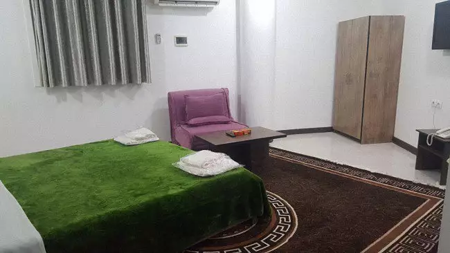 اتاق سان سیتی با تخت سبز و کمد چوبی