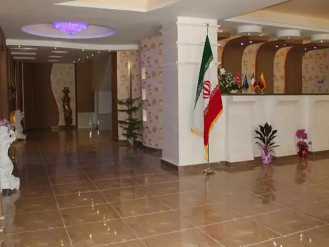 لابی هتل هالیس با پیشخوان پذیرش و پرچم ایران