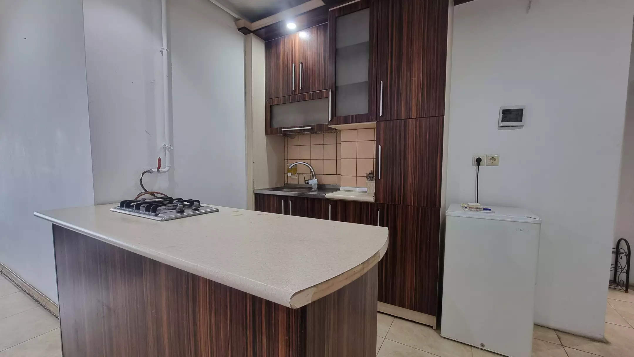 آشپزخانه با کابینت چوبی و جزیره در هتل سفیر