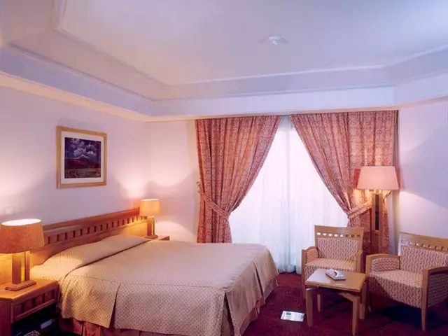 تخت دونفره و نشیمن اتاق هتل پارس