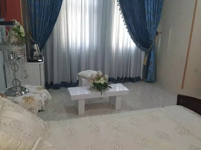 تخت دونفره و میز گل‌آرایی‌شده در هتل دربند