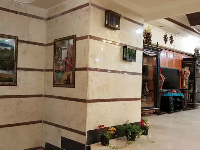 دیوار سنگی راهروی هتل دربند با گلدان و تابلو
