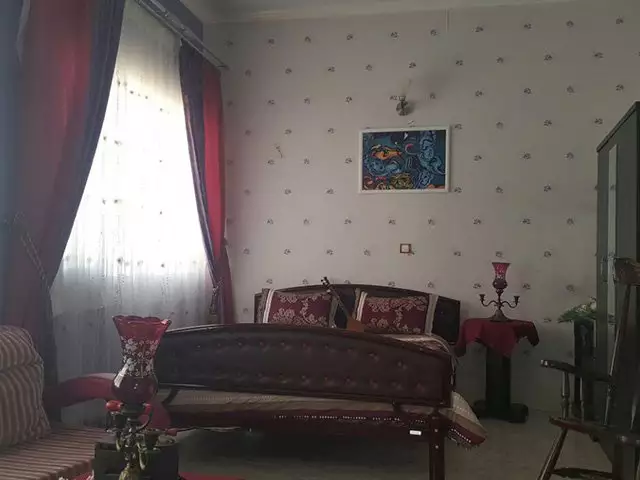 نشیمن هتل دربند با کاناپه و پرده‌های قرمز