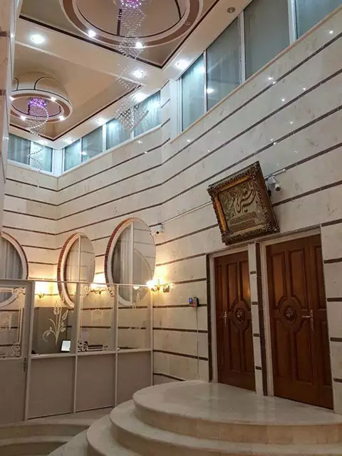 لابی هتل دربند با پله‌های نیم‌دایره و درهای چوبی