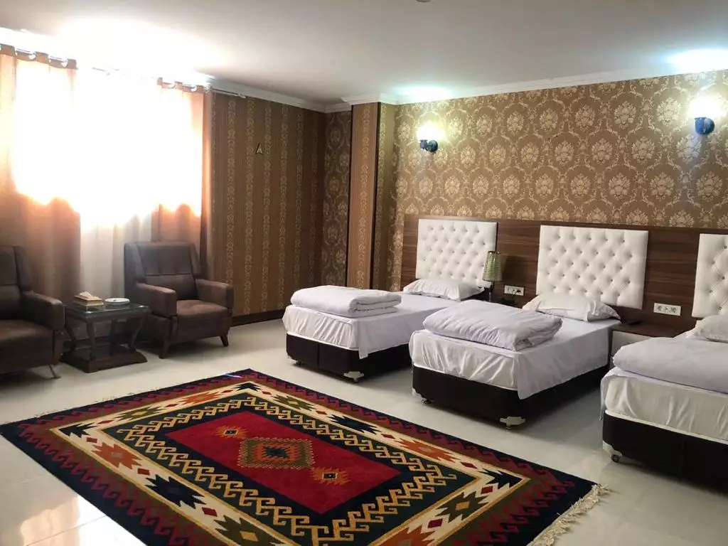 اتاق هتل عطر سیب با سه تخت و فرش سنتی