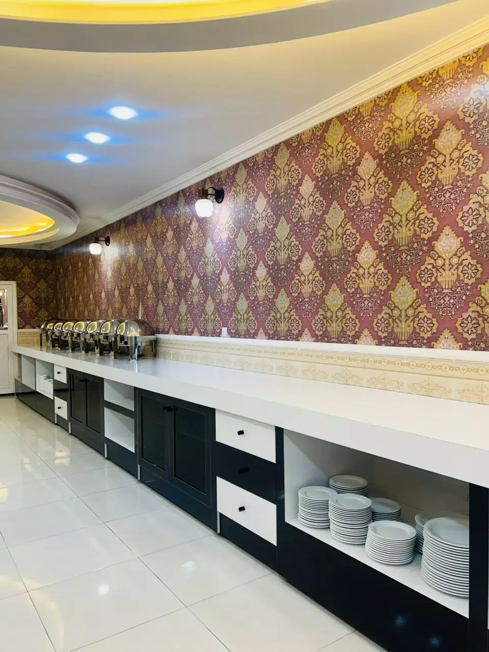 کانتر پذیرایی با ظروف چیده‌شده در هتل عطر سیب