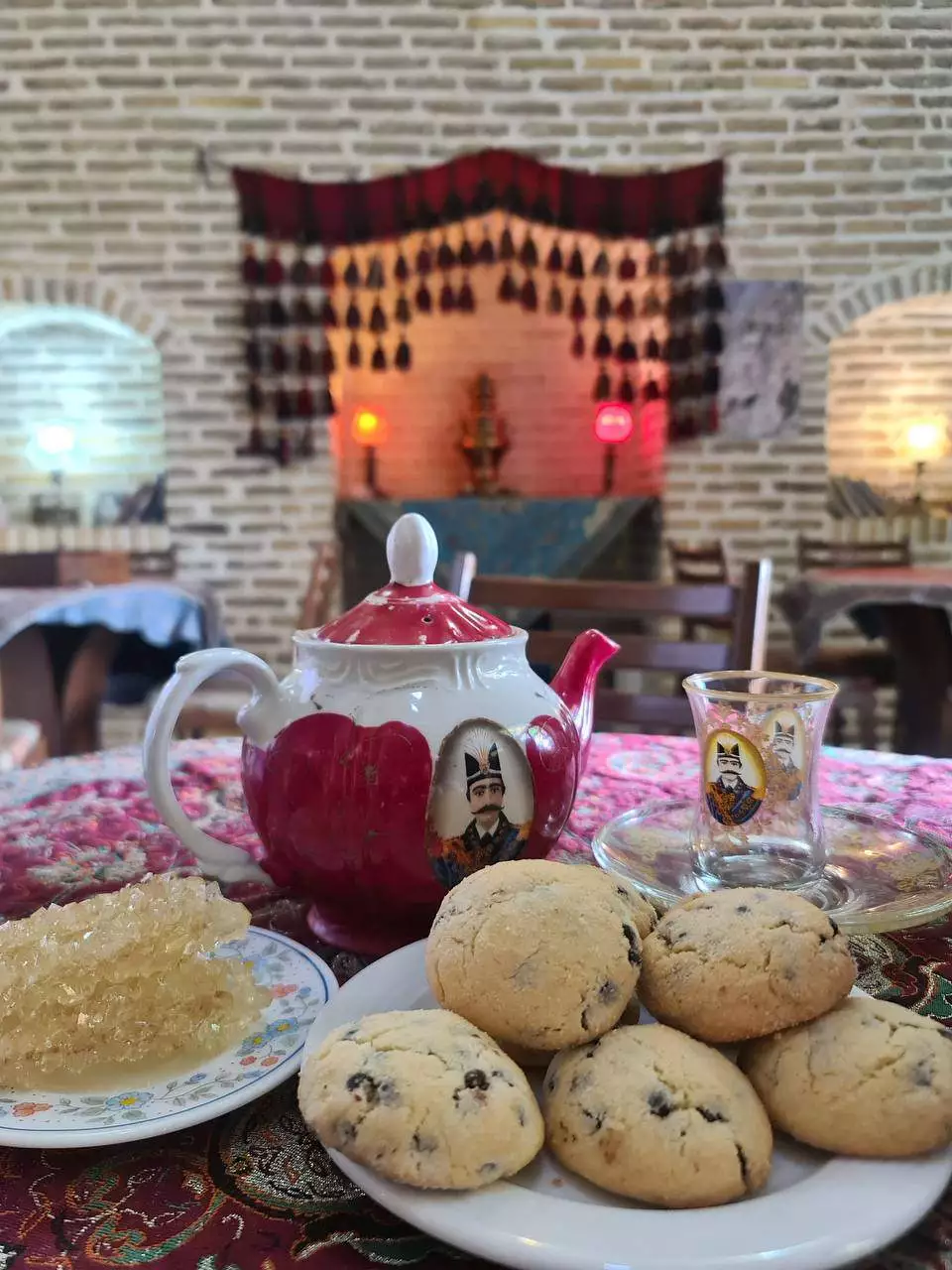 قوری چای و شیرینی روی میز هتل لاله بیستون