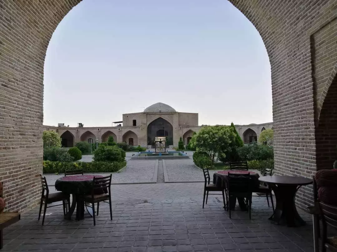 حیاط هتل لاله بیستون با حوض و میزهای فضای باز