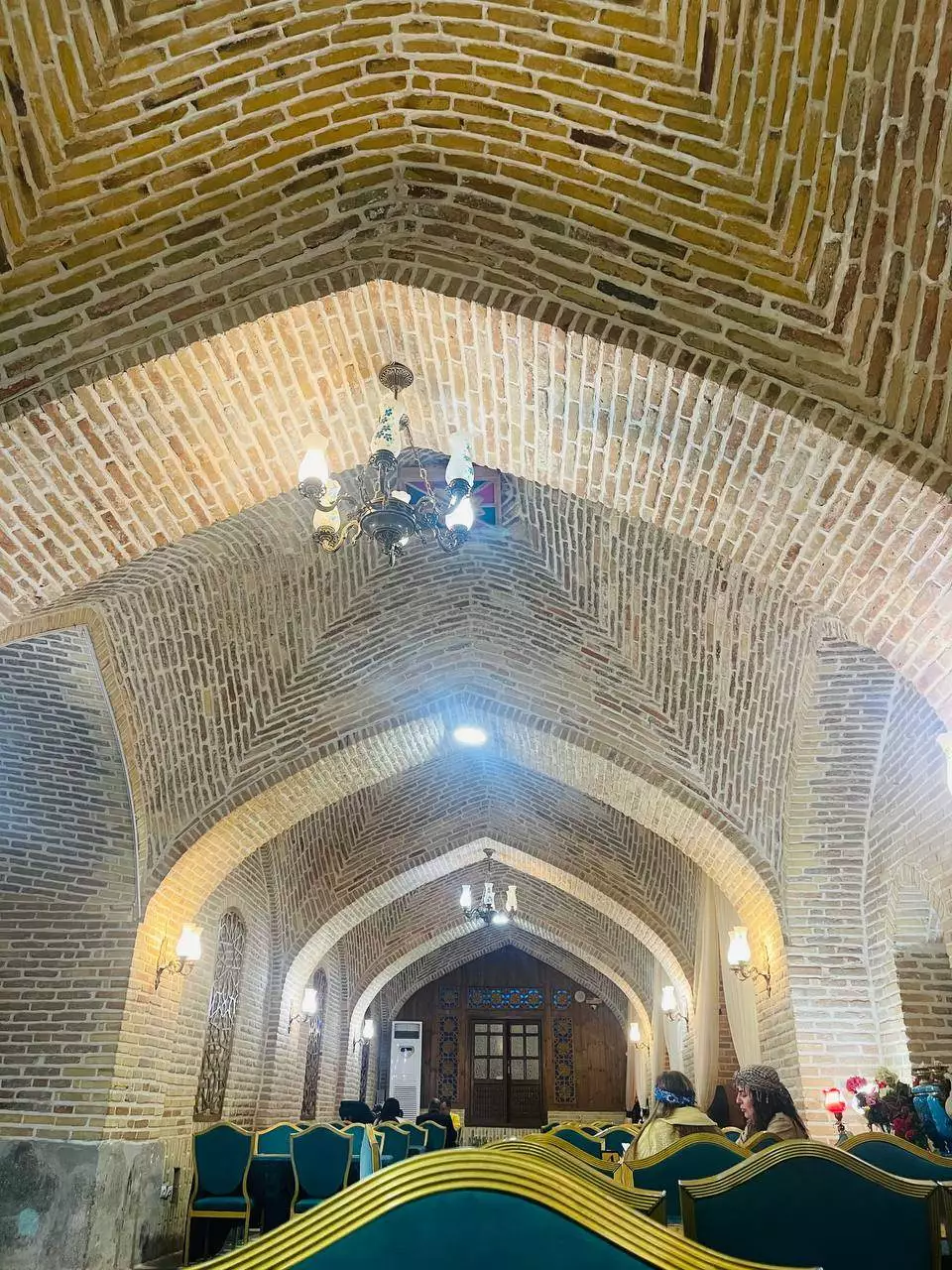 سالن طاقدار آجری هتل لاله بیستون با صندلیهای سبز