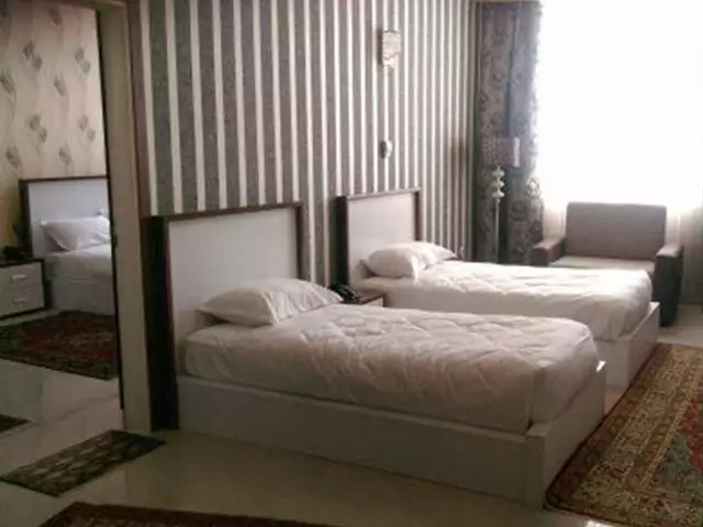 دو تخت یک‌نفره در اتاق هتل بزرگ گوت که مال سابق