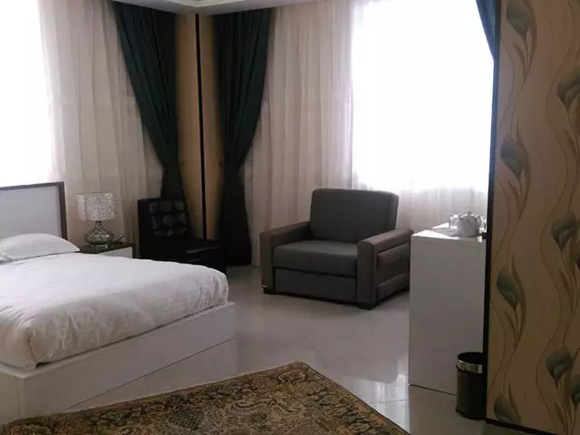 تخت و مبل راحتی در اتاق هتل بزرگ