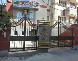 ورودی آپارتمان بهار با دروازه فلزی و تابلوی سردر