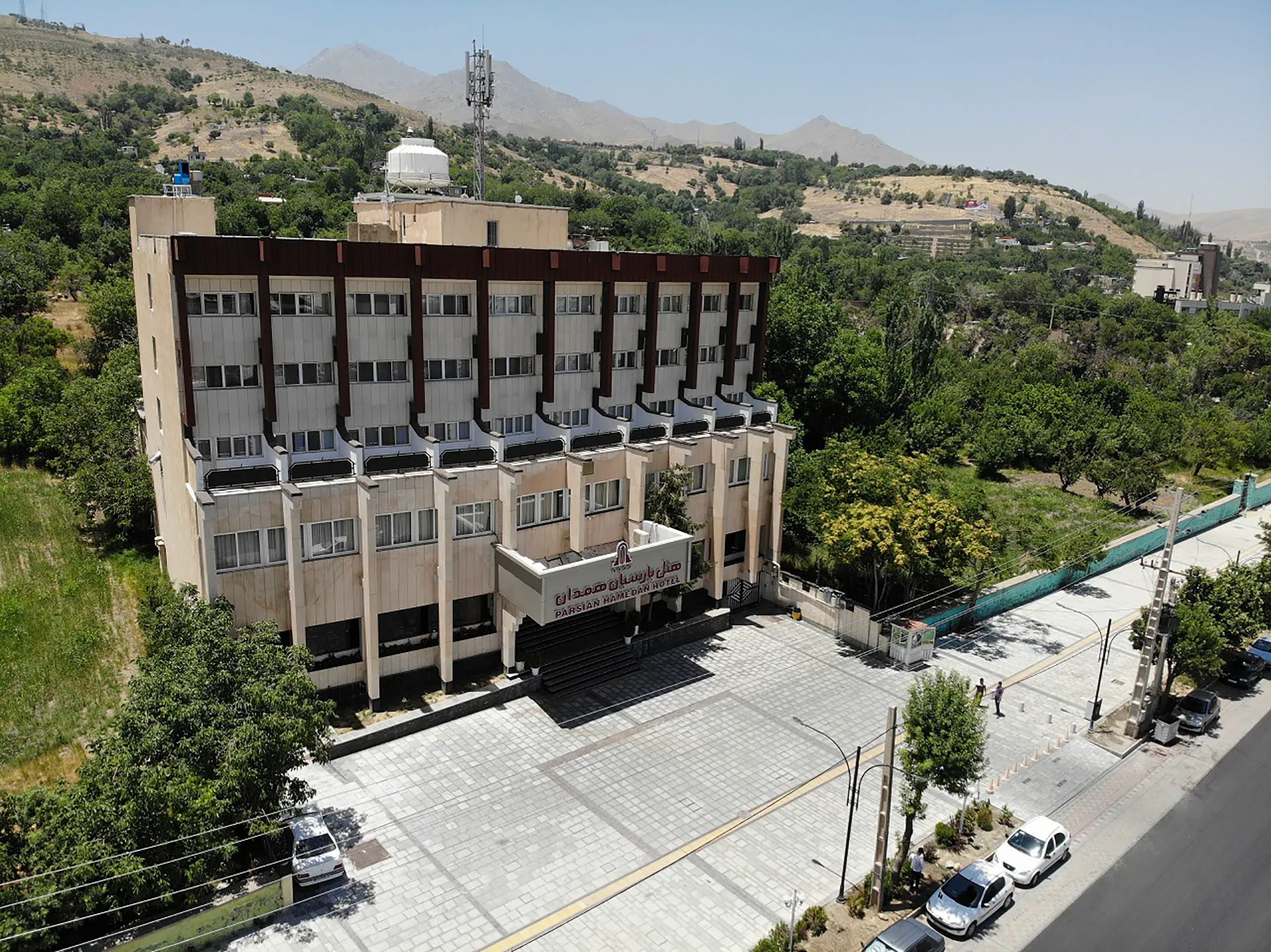 نمای بیرونی هتل پارسیان در میان فضای سبز و کوهستان