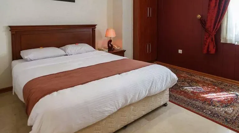 تخت دونفره و فرش اتاق هتل کوروش
