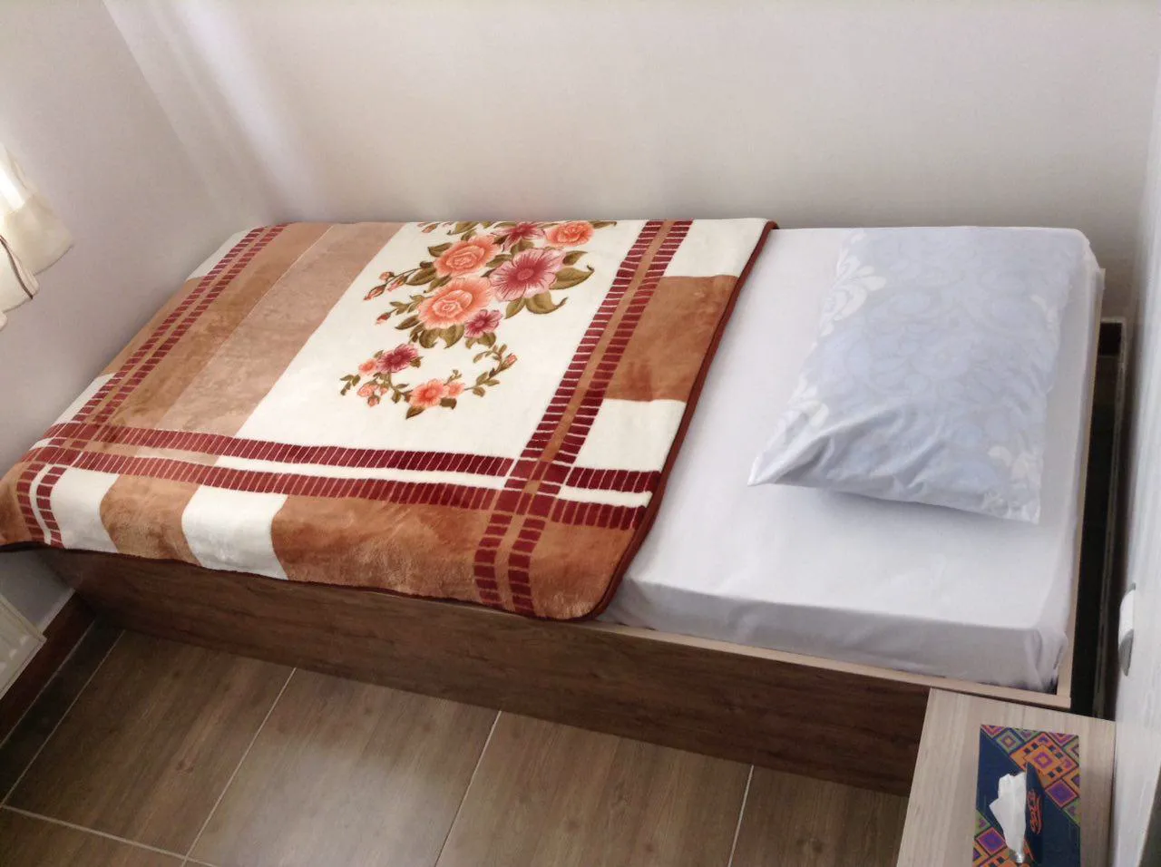 تخت یکنفره با روتختی گلدار در مرزبانی شاندرمن