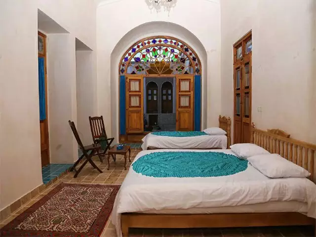 اتاق دوخوابه خانه مرشدی با پنجره شیشه‌رنگی