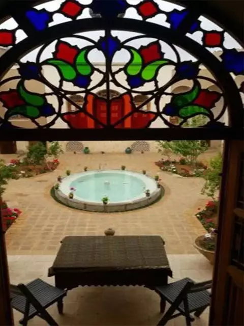 حیاط خانه مرشدی با حوض و شیشه رنگی