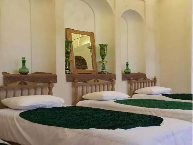 تخت‌های اتاق سنتی خانه مرشدی با روتختی سبز