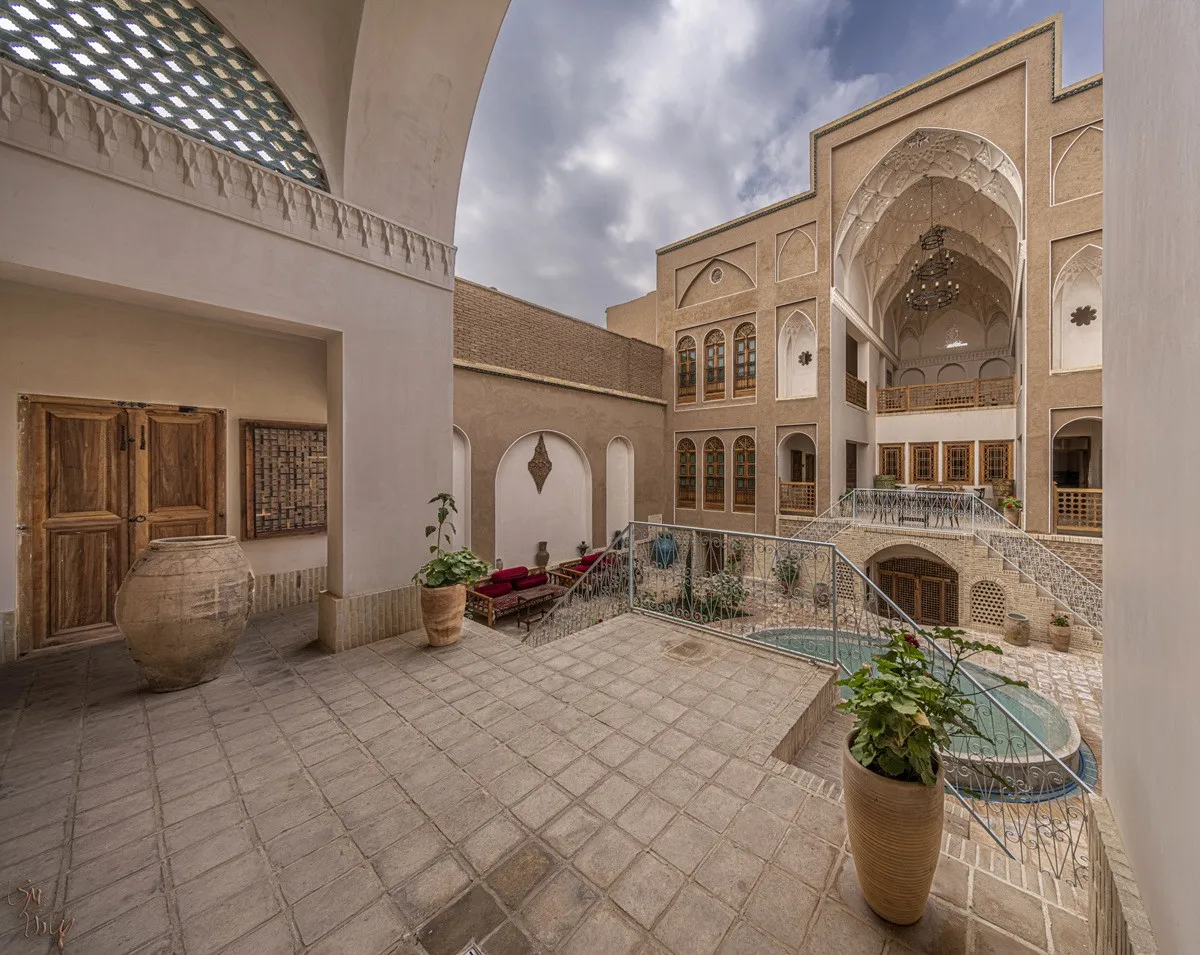 حیاط خانه مرشدی با معماری آجری و ایوان قوسی