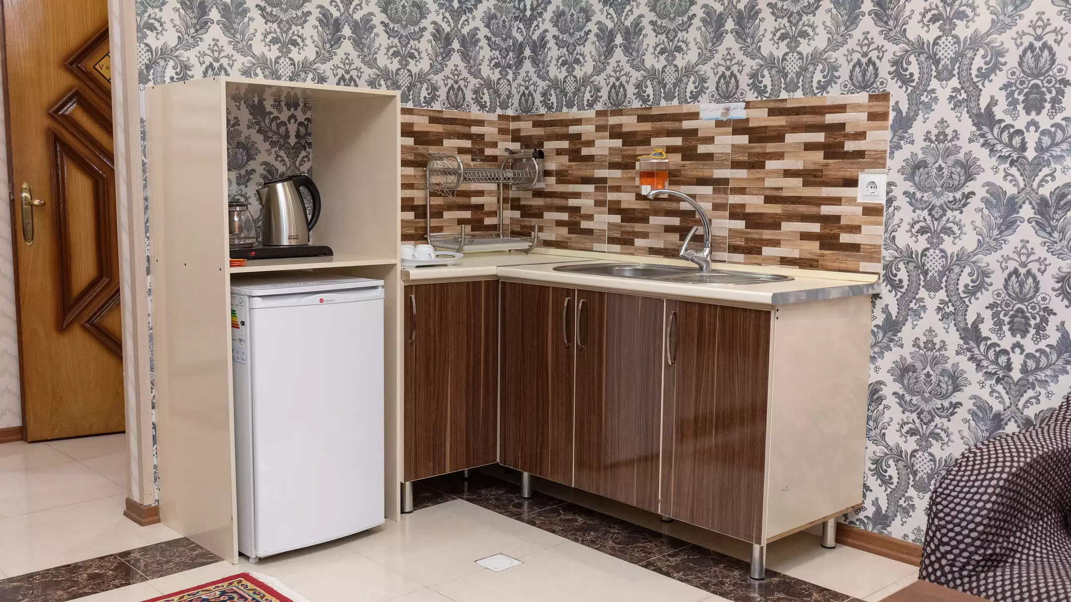 آشپزخانه هتل کوروش با سینک و کابینت چوبی