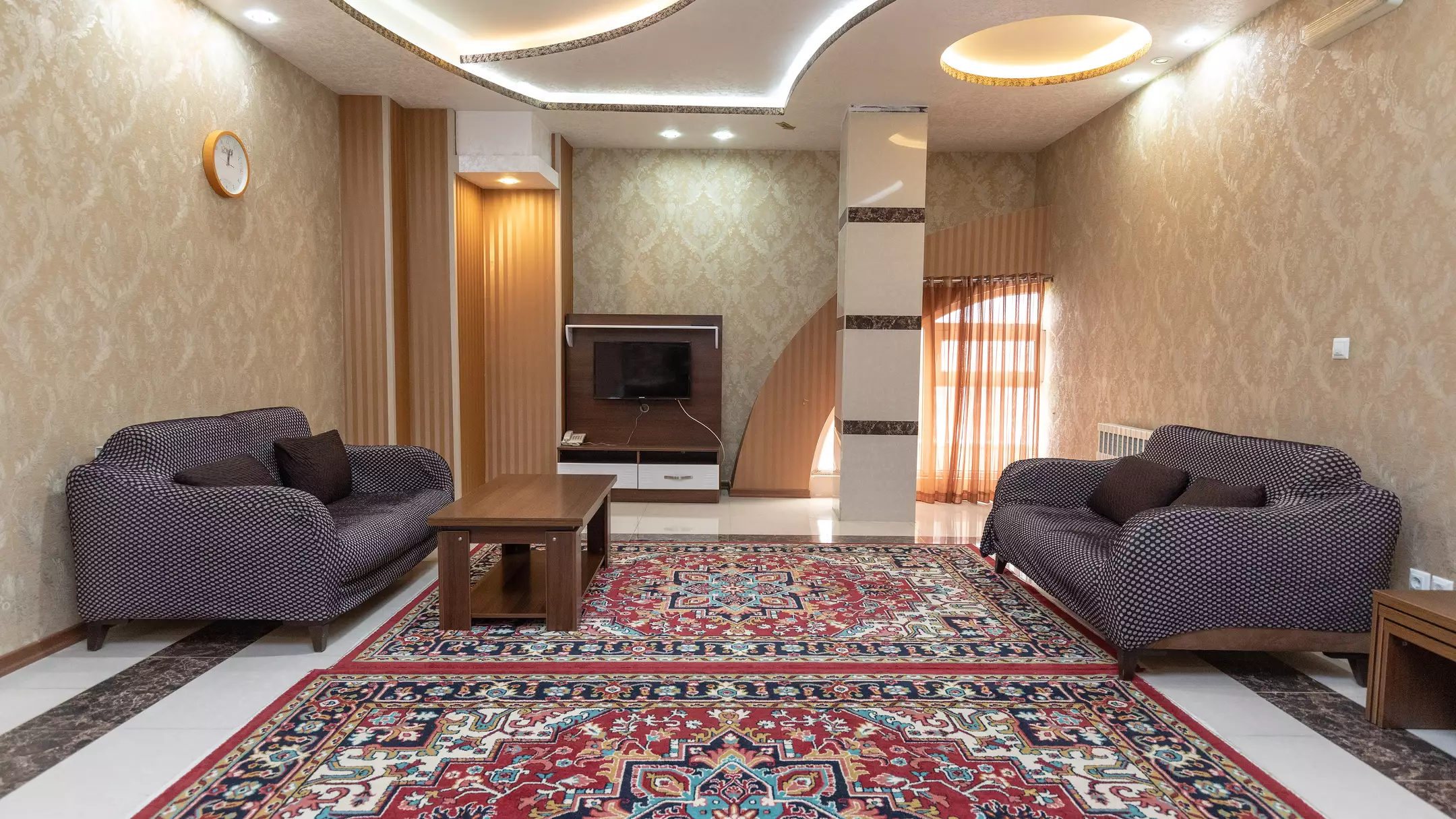 پذیرایی کوروش با دو دست مبل و فرش ایرانی
