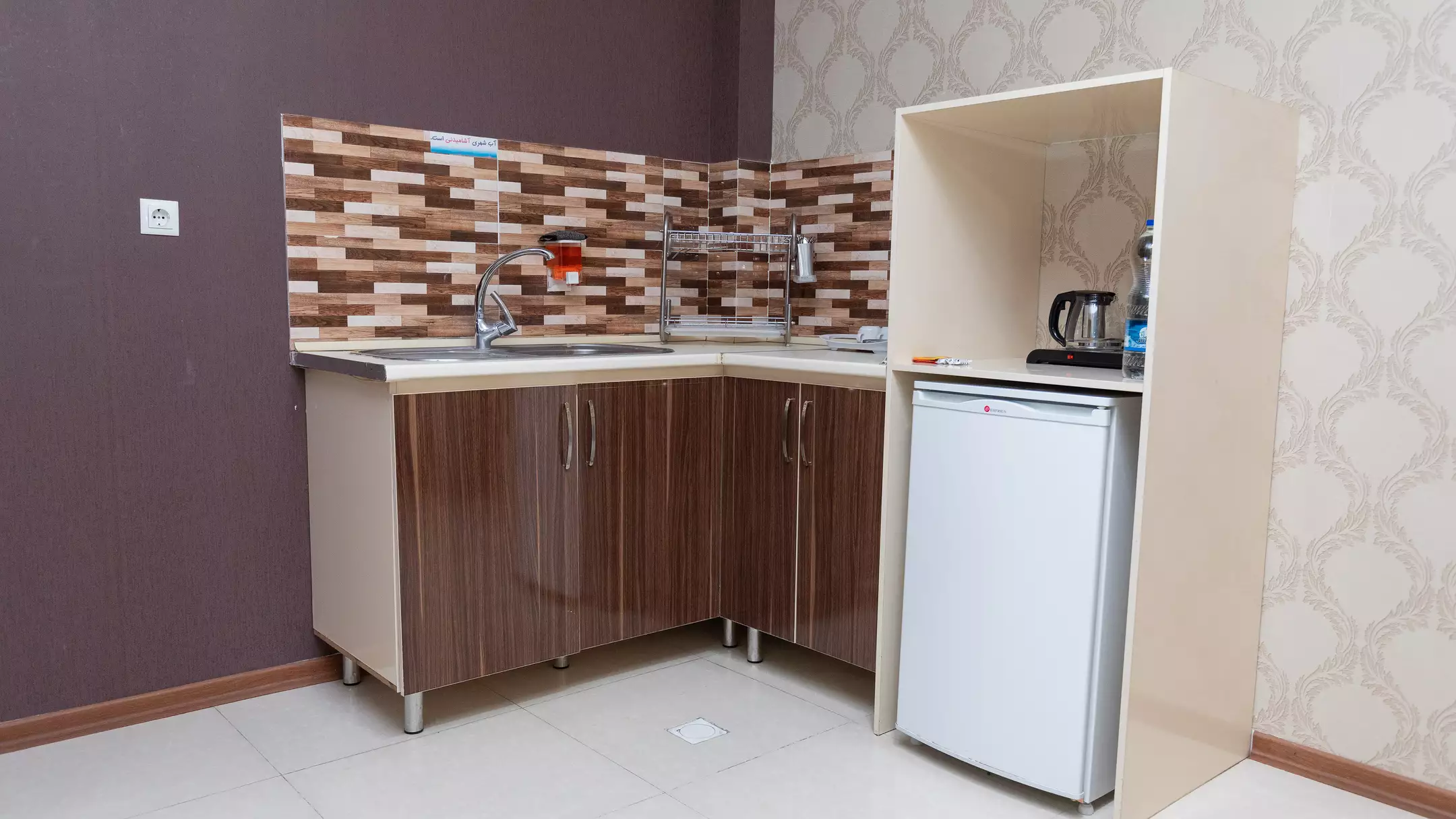 آشپزخانه کوچک با کابینت و یخچال در هتل کوروش