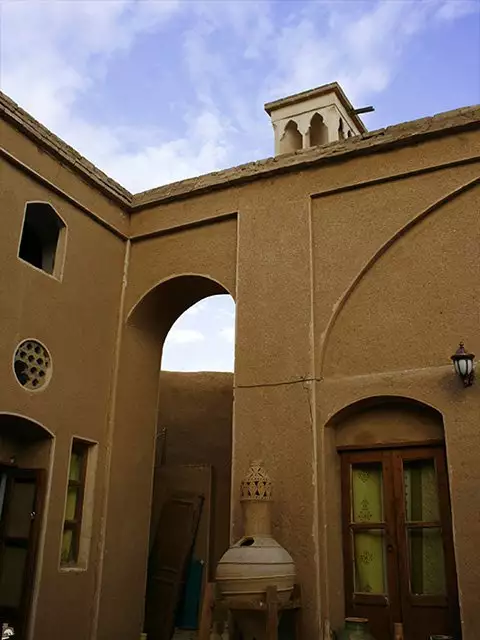 حیاط خانه نقلی با طاقهای خشتی و پنجرههای چوبی