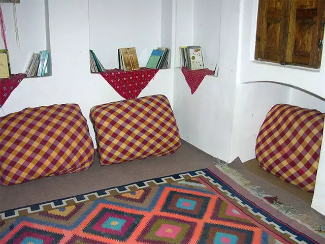 اتاق خانه نقلی با پشتیهای چهارخانه و فرش رنگارنگ