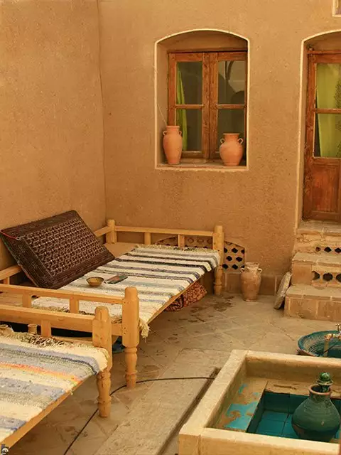 تختهای سنتی و حوض کوچک در حیاط خانه نقلی
