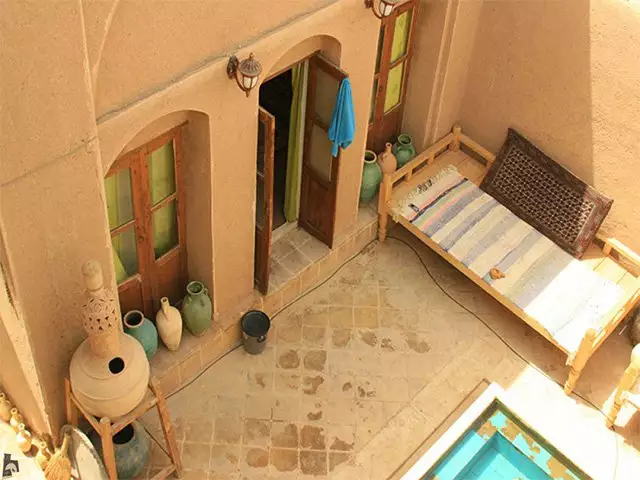 تخت سنتی کنار حوض در حیاط خانه نقلی